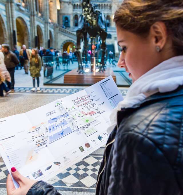 Woman looking at a map of the Natural History Museum