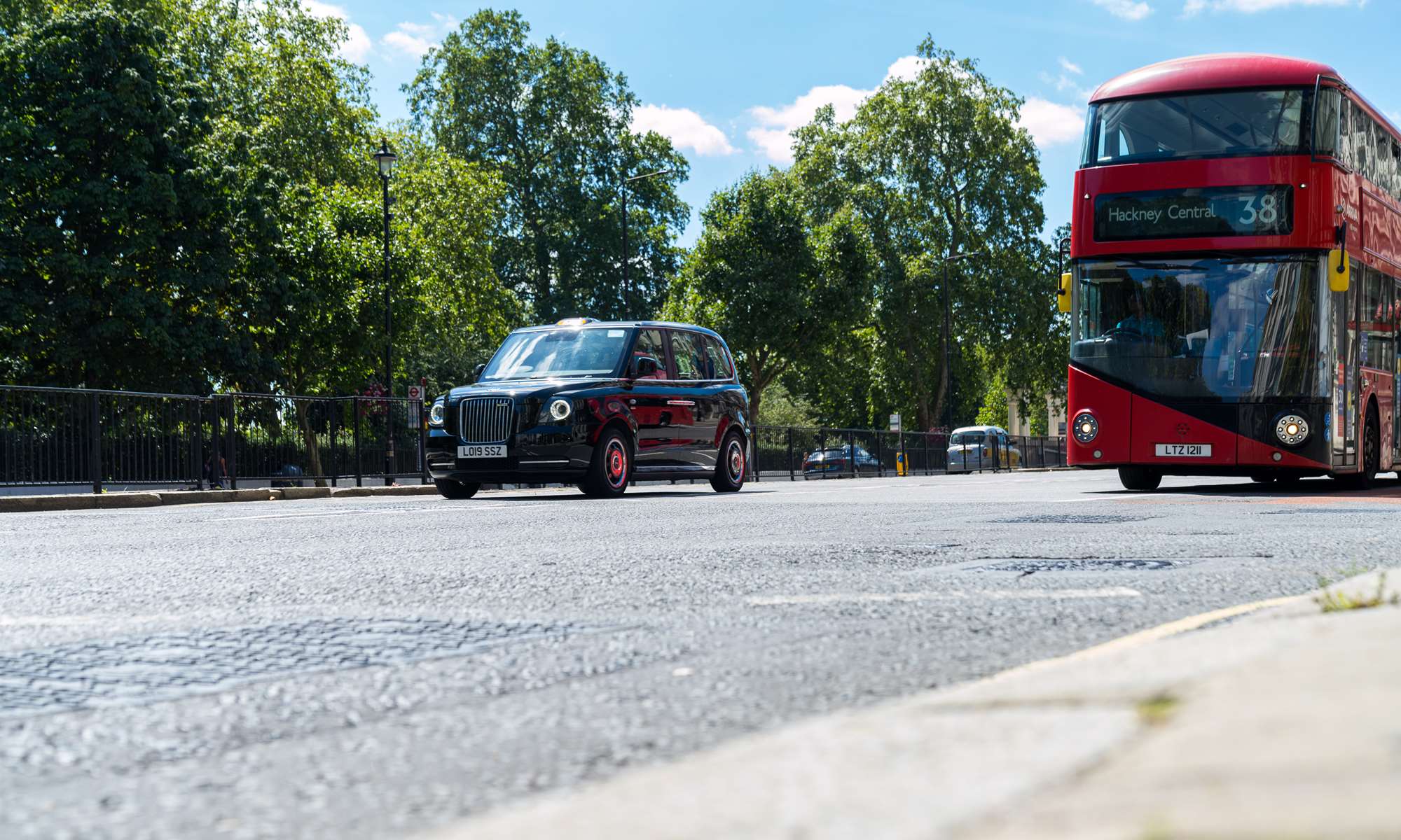 Day time view of red bus and taxi on a London street