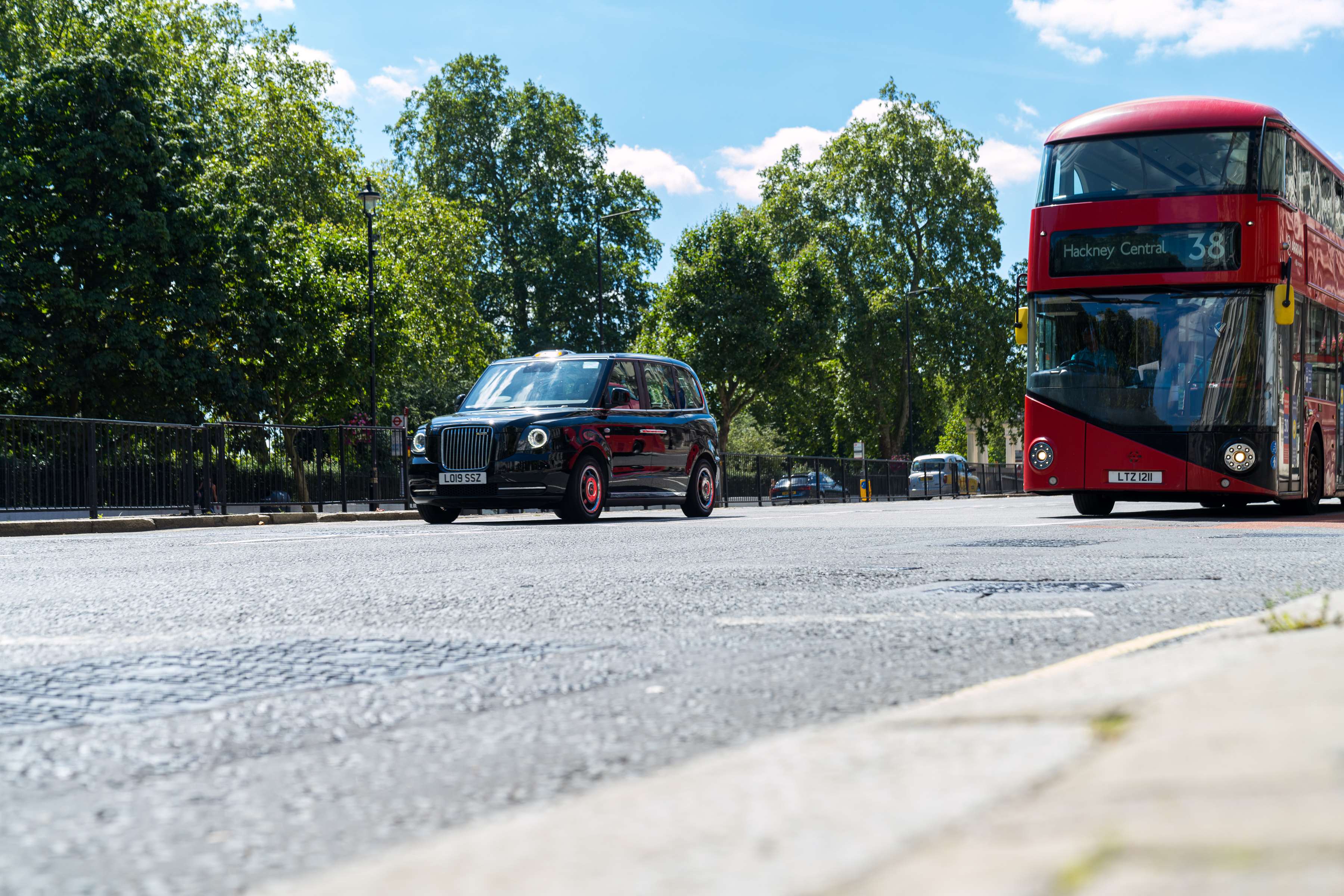 Day time view of red bus and taxi on a London street