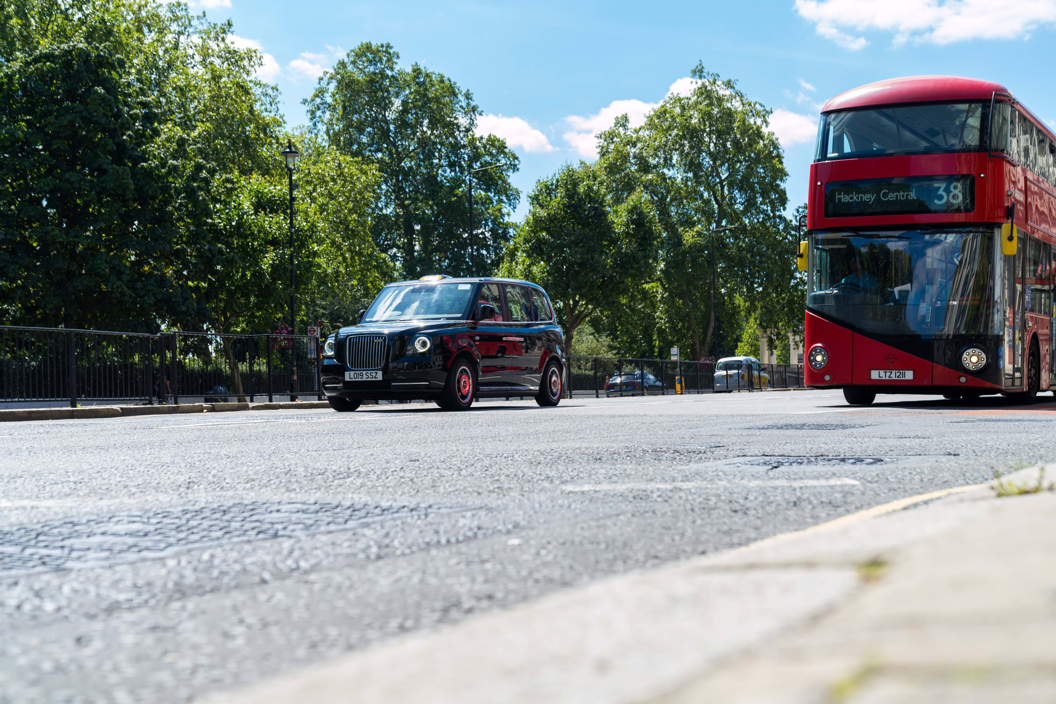 Day time view of red bus and taxi on a London street
